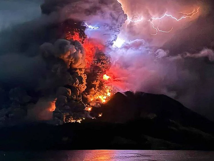 This handout photograph taken and released by the Center for Volcanology and Geological Hazard Mitigation on April 17, 2024, shows Mount Ruang spewing hot lava and smoke as seen from Sitaro, North Sulawesi.