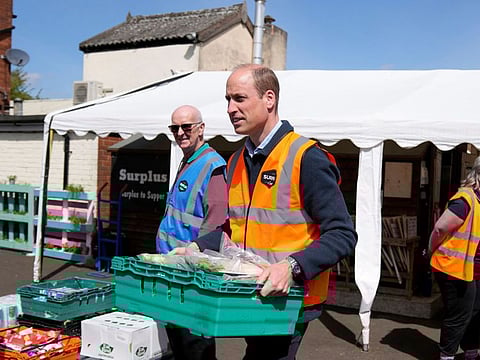 Britain's Prince William helps to load trays of food into vans during a visit to Surplus to Supper, a surplus food redistribution charity, in Sunbury-on-Thames, Surrey, on April 18, 2024.  