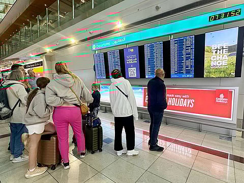 Passengers check flight information on screens at the Dubai International Airport in Dubai. Photo for illustrative purpose only