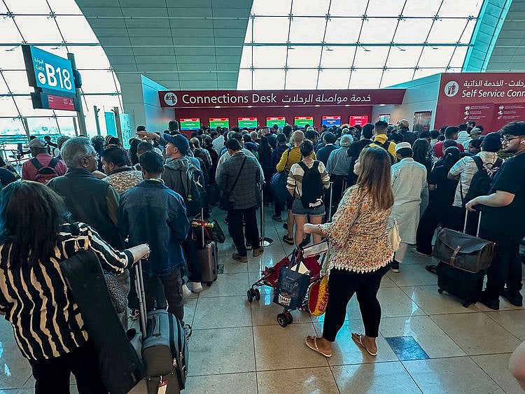 Passengers queue at a flight connection desk at the Dubai International Airport in Dubai. 