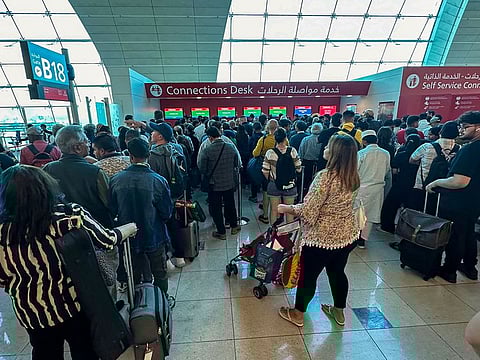 Passengers queue at a flight connection desk at the Dubai International Airport in Dubai. 