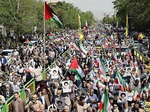 Iranian's wave the flags of Palestine and Iran as they gather during an anti-Israel demonstration after the Friday noon prayer in Tehran on April 19, 2024. World leaders appealed for calm on April 19 after reported Israeli retaliation against Iran added to months of tense spillover from the war in Gaza, with Iranian state media reporting explosions in the central province of Isfahan. 