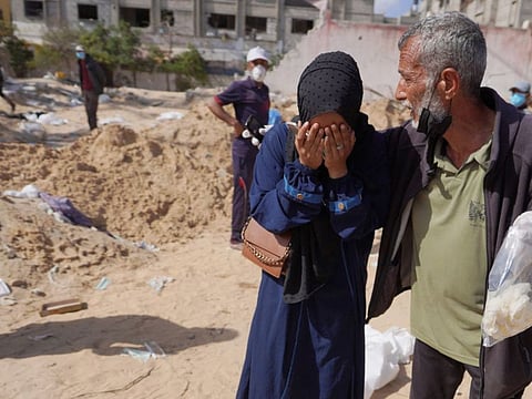 Palestinians react after the body of a relative was found buried by Israeli forces in Nasser hospital compound in Khan Yunis in the southern Gaza Strip on April 21, 2024.