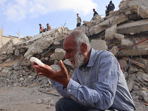 A Palestinian waits for news of his daughter as rescue workers search for survivors under the rubble of a building hit in an overnight Israeli bombing in Rafah, in the southern Gaza Strip, on April 21, 2024.  