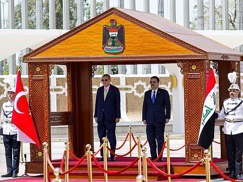 Iraq's Prime Minister Mohammed Shia Al Sudani (right) and Turkey's President Recep Tayyip Erdogan take part in a welcoming ceremony at the Baghdad International airport in Iraq's capital on April 22, 2024.  