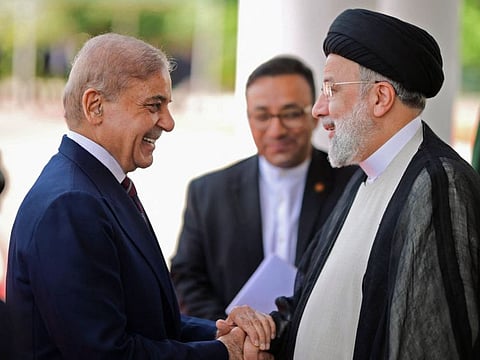 Irans President Ebrahim Raisi (right) being greeted by Pakistan's Prime Minister Shehbaz Sharif upon his arrival in Islamabad on April 22.