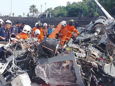 Rescuers inspecting the crash site after two military helicopters collided in Lumut in Malaysia's Perak state.