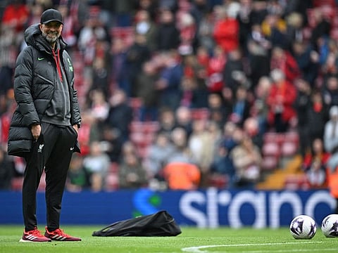 Liverpool's manager Jurgen Klopp checks out the pitch conditions ahead of the English Premier League football match against Crystal Palace at Anfield in Liverpool, north west England on April 14.