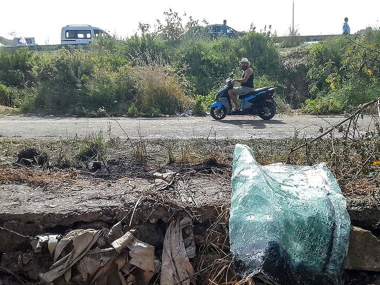 A motorist rides a motorcycle past the site of an Israeli strike