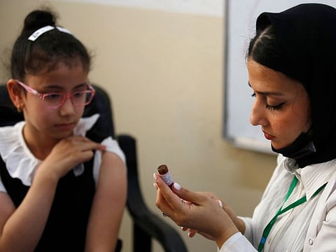 A schoolgirl receives a measles vaccine at a school in Baghdad, on April 14, 2024, part of a vaccination campaign for school students across Iraq.  