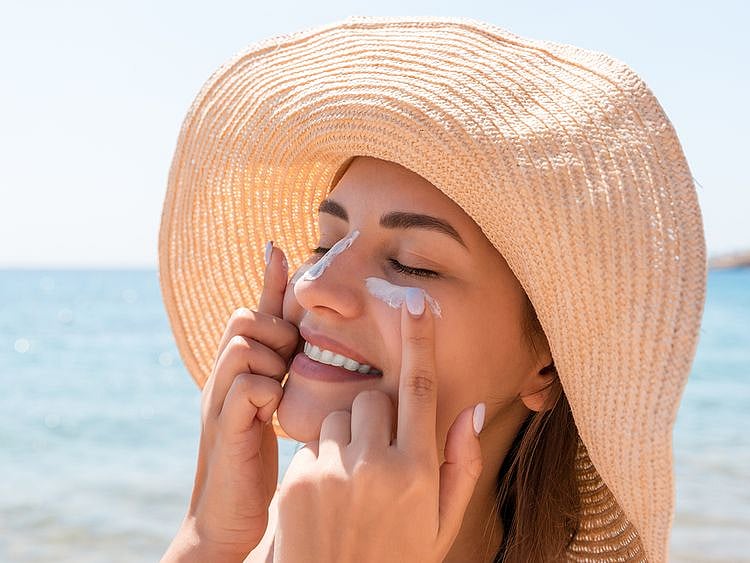 Woman putting sunscreen