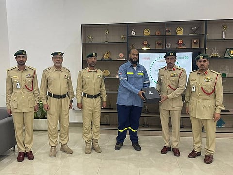 Ali Jamal Al Balushi receiving a certificate of appreciation from Brigadier Sultan Abdullah Al Owais, director of Al Qusais Police Station
