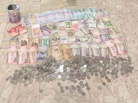 Dubai Police display a large amount of cash found in the possession of a beggar