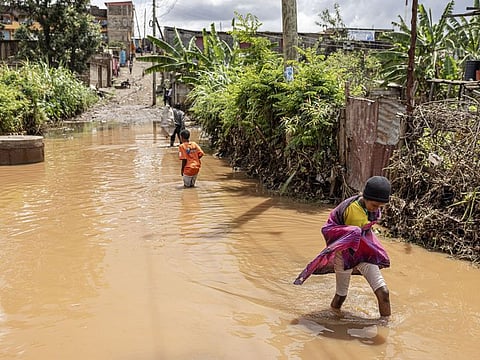 Children wade through floodwater around homesteads following heavy rains in the Githurai district of Nairobi.