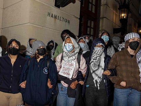 Student protesters sit watch outside Hamilton Hall, where students at Columbia University continue protesting in support of Palestinians barricaded themselves inside the building.