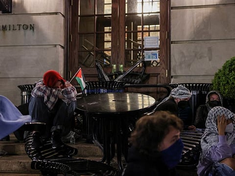 Student protesters sit watch outside Hamilton Hall, where students at Columbia University continue protesting in support of Palestinians barricaded themselves inside the building.