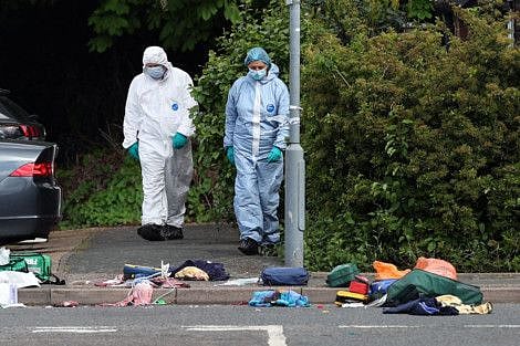 Police forensic officers examine the crime scene in Hainault, east of London on April 30, 2024, where a 36-year-old man wielding a sword was arrested following an attack on members of the public and two police officers.  