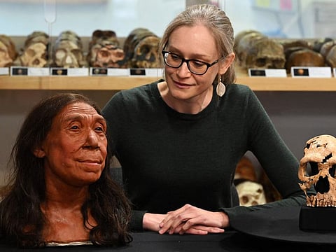 Associate Professor in the Evolution of Health, Diet and Disease, Dr Emma Pomeroy, poses for a photograph with the rebuilt skull and a physical reconstruction of the face and head, of a 75,000-year-old Neanderthal woman, named Shanidar Z, at the University of Cambridge, eastern England, on April 25, 2024.  