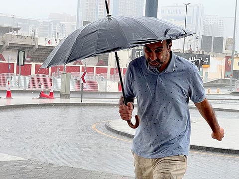 A Dubai resident scampers across the street during heavy rain in Al Qusais on May 2, 2024. Although it didn't rain heavily, people generally heeded the warning and stayed home.