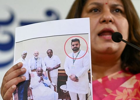 Congress spokesperson Supriya Shrinate shows a photograph featuring Prajwal Revanna who was summoned for alleged sexual abuse case, at a press conference in Bengaluru on May 1, 2024.  