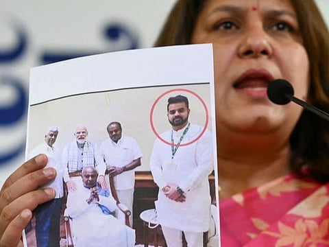 Congress spokesperson Supriya Shrinate shows a photograph featuring Prajwal Revanna who was summoned for alleged sexual abuse case, at a press conference in Bengaluru on May 1, 2024.  