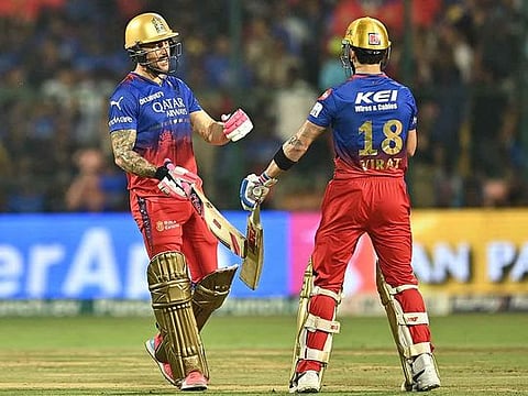 Royal Challengers Bengaluru's captain Faf du Plessis (L) greets teammate Virat Kohli during the Indian Premier League (IPL) Twenty20 cricket match between Royal Challengers Bengaluru and Gujarat Titans at the M Chinnaswamy Stadium in Bengaluru on May 4, 2024.
