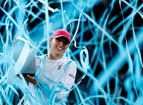 Poland's Iga Swiatek celebrates with the trophy after winning her final match against Belarus' Aryna Sabalenka at Madrid Open on Saturday.