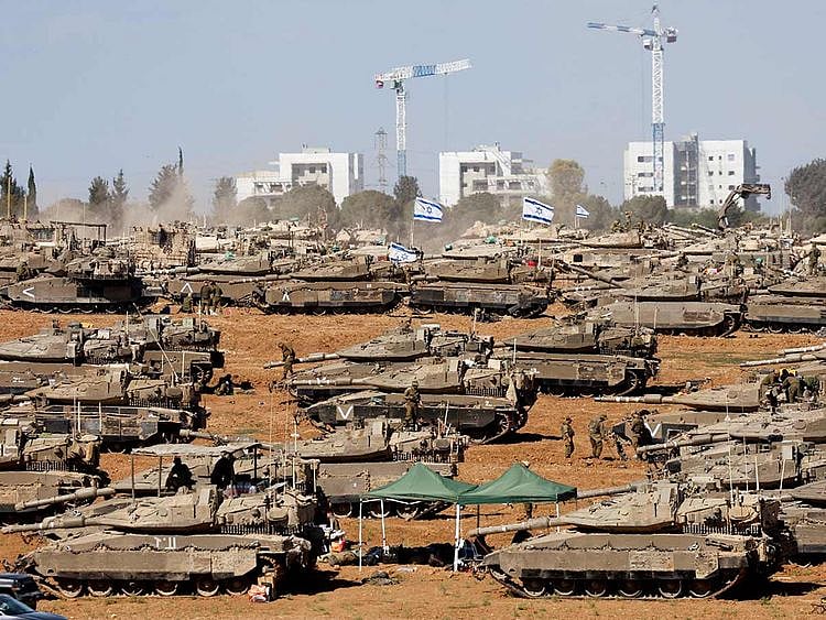 Israeli soldiers stand next to military vehicles, amid the ongoing conflict between Israel and the Palestinian Islamist group Hamas, near the Israel-Gaza Border, in southern Israel, May 7, 2024. 