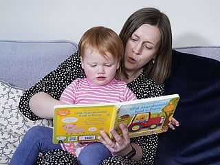 Opal Sandy, who was born completely deaf because of a rare genetic condition, and can now hear unaided for the first time after receiving ground-breaking gene therapy at 11-months-old, reads with her mother Jo at their home in Eynsham, Oxfordshire.