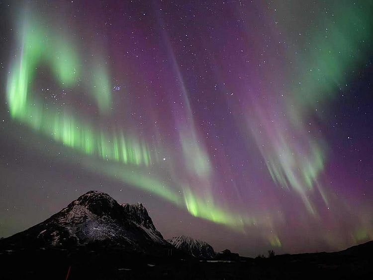This picture shows northern lights (Aurora Borealis) over the mountain at Utakleiv on March 3, 2024 in Lofoten Islands. A huge solar storm is heading for Earth, supercharging auroras and bringing possible disruptions to satellites and power grids as early as the evening of May 10, 2024, US officials say.