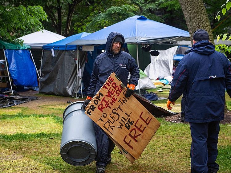 Maintenance staff and waste dispoable crews clean up after police cleared a pro-Palestinian protest encampment on the campus of the University of Pennsylvania in Philadelphia, Pennsylvania on May 10, 2024.