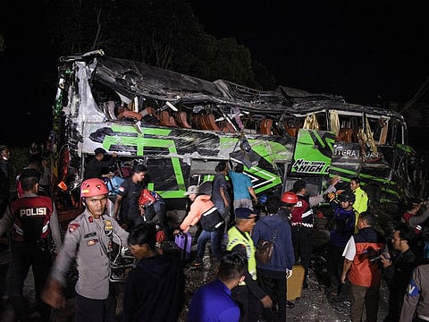 Officers check the debris and belongings of passengers after a bus crash.