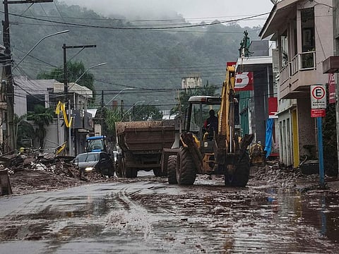 A worker cleans a street with a backhoe loader after the floods caused by heavy rains in Mucum, Rio Grande do Sul state, Brazil.