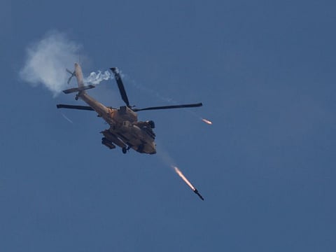 An Israeli military Apache helicopter fires missiles towards Gaza as seen from southern Israel, May 14, 2024.  