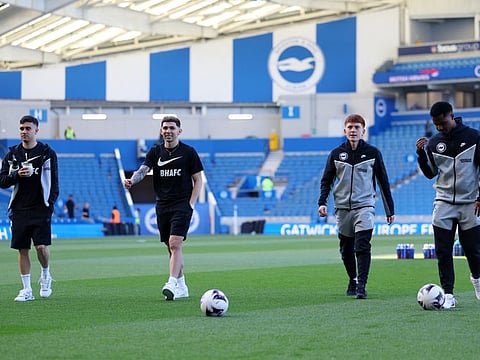 Brighton & Hove Albion's Julio Enciso and Facundo Buonanotte with teammates on the pitch before the match.