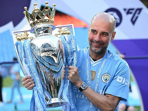 Manchester City's Spanish manager Pep Guardiola poses with the Premier League trophy after the presentation ceremony at the Etihad Stadium in Manchester on Sunday.