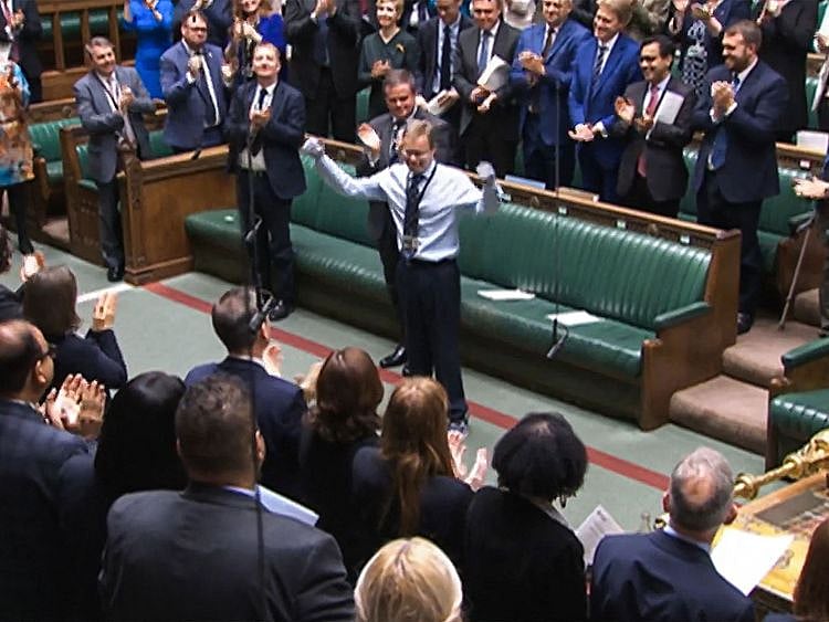 A video grab from footage broadcast by the UK Parliament's Parliamentary Recording Unit (PRU) shows Britain's Conservative MP Craig Mackinlay acknowledging the applauses and cheering, in the House of Commons, in London, on May 22, 2024 on the day of his coming back ahead of the weekly session of Prime Minister's Questions (PMQs) in the House of Commons.