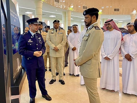 Sharjah Police Chief Maj Gen Al Shamsi (R) briefed by a winner from Qatar about a research project