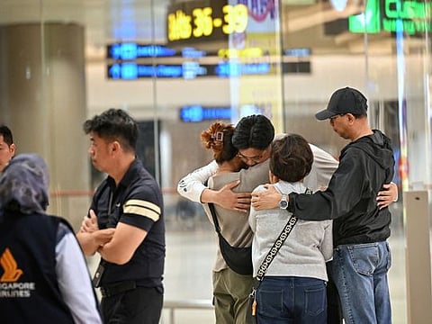Passengers of Singapore Airlines flight SQ321 from London to Singapore, which made an emergency landing in Bangkok, are escorted by ground staff upon arrival at Changi Airport in Singapore on May 22, 2024.  