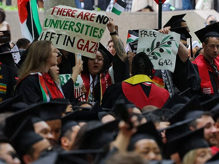 Graduating students hold a sign reading "There Are No Universities Left in Gaza" during the 373rd Commencement Exercises at Harvard University, amid the ongoing conflict between Israel and the Palestinian Islamist group Hamas, in Cambridge, Massachusetts, US, on May 23, 2024.   