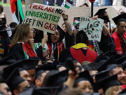 Graduating students hold a sign reading "There Are No Universities Left in Gaza" during the 373rd Commencement Exercises at Harvard University, amid the ongoing conflict between Israel and the Palestinian Islamist group Hamas, in Cambridge, Massachusetts, US, on May 23, 2024.   