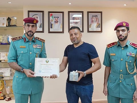 Colonel Ghaith Khalifa Al Kaabi (1st left) presenting certificate of appreciation to Abdul Fattah Mahmoud Abdel Fattah for his honesty.