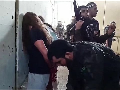 This video grab from footage released by the Israeli Hostage and Missing Families Forum campaign group on May 22, 2024, shows what the group described as Israeli female soldiers being captured by Palestinian Hamas militants during the October 7, 2023 attack on Israel.  