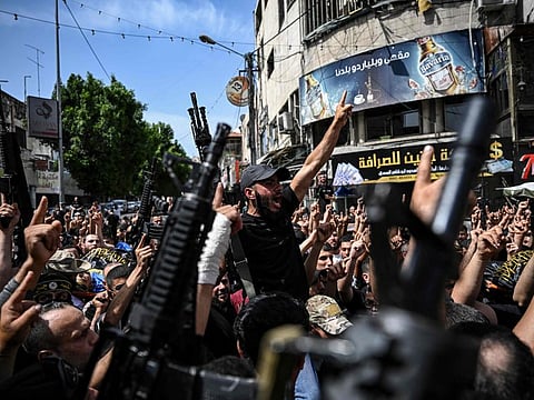 Palestinian militants attend a group funeral of people killed in a raid by Israeli forces, in Jenin, in the occupied West Bank on May 23, 2024.  