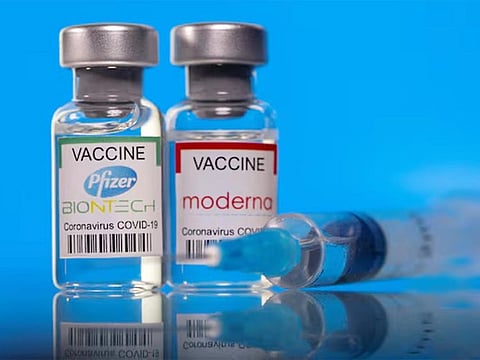 Vials with Pfizer-BioNTech and Moderna coronavirus disease (COVID-19) vaccine labels are seen in this illustration. 