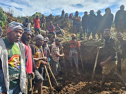 Locals gather amid the damage after a landslide in Maip Mulitaka, Enga province, Papua New Guinea.