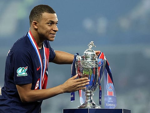 Paris St Germain's Kylian Mbappe celebrates with the trophy after winning the Coupe de France.