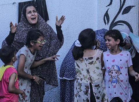  Palestinians react after an Israeli strike on a building in Nuseirat on May 25, 2024.