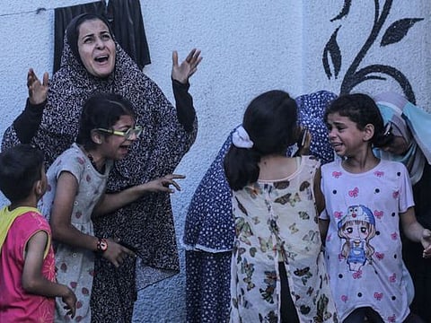  Palestinians react after an Israeli strike on a building in Nuseirat on May 25, 2024.
