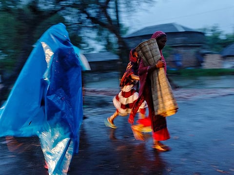 People move with their belongings to the cyclone shelter before Cyclone Remal hits the country in the Shyamnagar area of Satkhira, Bangladesh.